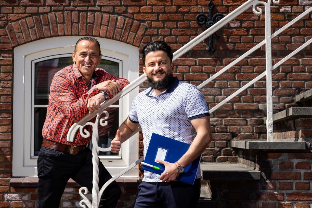 twee mannen poseren voor het gemeentehuis van Lichtenvoorde