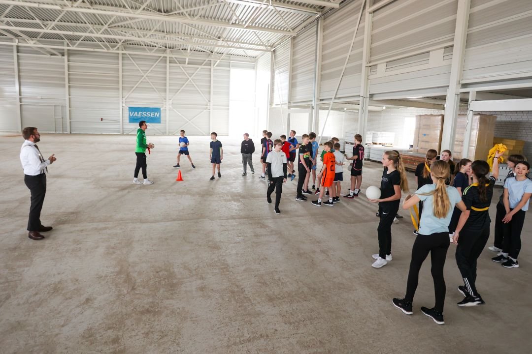 wethouder spreekt leerlingen toe in de sporthal