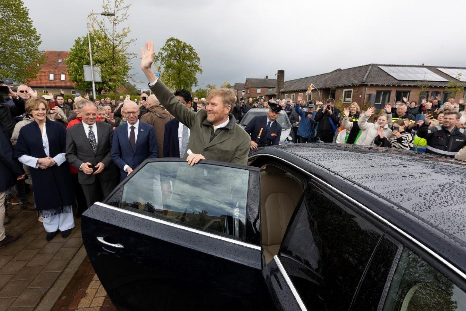 Koning Willem-Alexander zwaait naar de vele aanwezigen in Mariënvelde. 