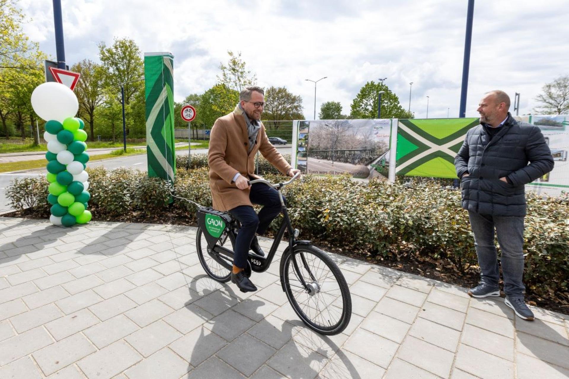 Wethouder Bart Porskamp onthult al fietsend het aanwijzingsbord van de HUB.
